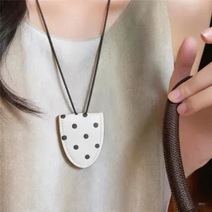 Close-up detail of a minimalist leather polka dot glasses holder necklace for women
