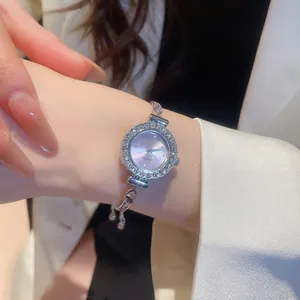 Close-up detail of a elegant silver watch bracelet with rhinestones and purple dial