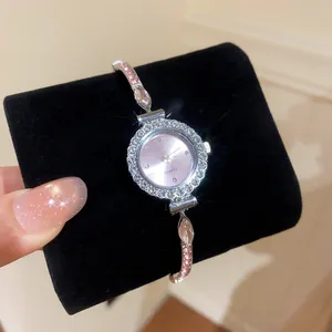 Close-up of elegant rhinestone-encrusted round watch with pink crystal bracelet band