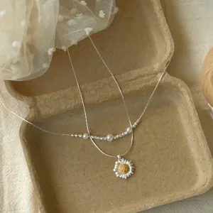 Dettaglio ravvicinato del pendente a fiore in zircone e dei livelli della collana