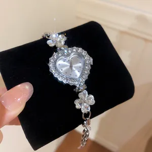 Detail showing sparkling rhinestone heart-shaped watch face with flower bracelet links