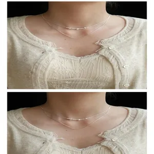 Vista dettagliata di una collana in argento a due strati con delicate perle su una modella.