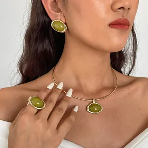 Close-up van een retro groene hars sieradenset met choker, ring en oorknopjes op model.