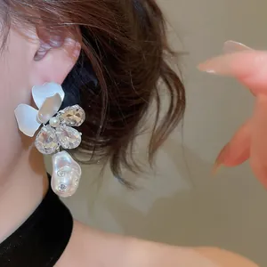 Detailansicht französischer Blumenohrringe mit Kristallen und Barockperle am Modell