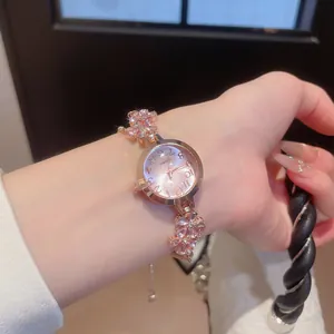 Detailed view of rose gold flower bracelet watch with pink rhinestones on woman wrist