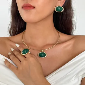 Elegante vintage sieradenset met groene ovale hars hangers gedragen door een model