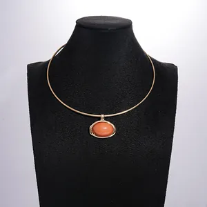 Gedetailleerde weergave van een vintage ovalen hars hanger op een gouden halsketting