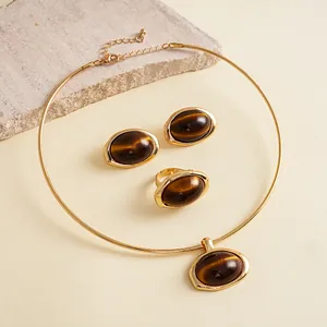 Gedetailleerd overzicht van een vintage gouden sieradenset met ovale tijgeroog-effect harsen stenen