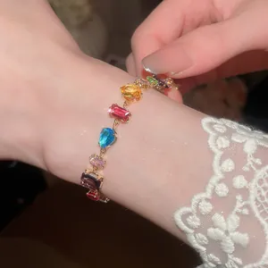 Nahaufnahme des bunten geometrischen Zirkonia-Armbands am Handgelenk mit Spitze.