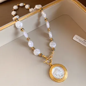 Close-up of French vintage pearl necklace with a round relief portrait pendant