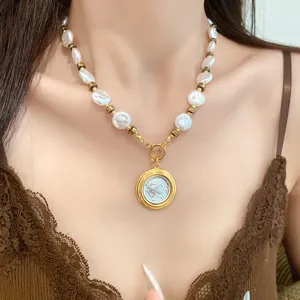 Close-up of a vintage pearl necklace with a classical gold coin portrait pendant