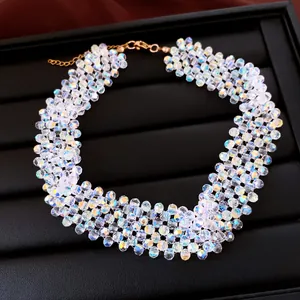 Nahaufnahme einer irisierenden geometrischen Perlenhalskette mit goldenem Verschluss.