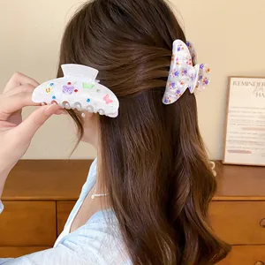 Vista detallada del uso de bonitas pinzas para el pelo de acrílico con flores y mariposas