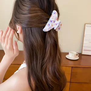 Vista detallada de una elegante pinza para el cabello de acrílico floral en un peinado suave