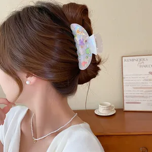 Primer plano de una pinza para el cabello de acrílico con mariposas de colores