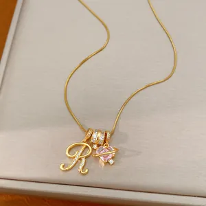 Detailopname van 18k vergulde ketting met zirkonia letter R en roze hart