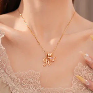 Detail van de 18k vergulde ketting met letter R en sprankelende roze harthanger