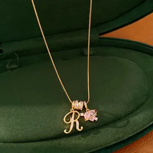 Macro-opname van 18k vergulde ketting met letter R en roze hartvormige hangers