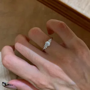 Detailed view of an exquisite French style zircon round open ring on a female finger