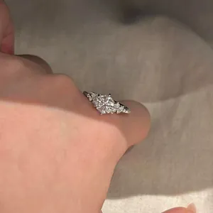 Close-up of a sparkling round zircon ring on a finger with a French luxury design