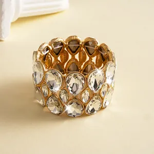 Detailed close-up of a gold-tone luxury elastic bracelet with double-layer teardrop crystals