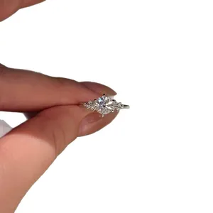 Elegant silver-tone round zircon ring with side stone accents displayed on a hand model