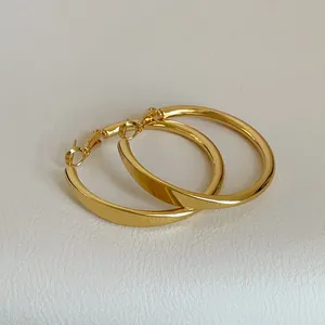 Detailansicht der polierten goldenen Creolen mit minimalistischem rundem Design