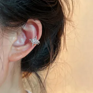 Detailed macro view of a sparkling zircon star-shaped ear cuff on a model's ear
