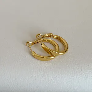 Nahaufnahme von minimalistischen goldenen Creolen mit glattem, poliertem Finish