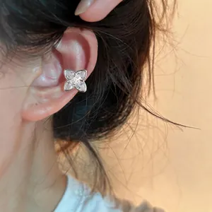 Close-up of a sparkling zircon clover ear cuff worn on the upper ear bone.