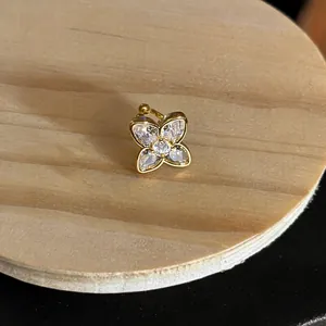 Close-up of a gold-plated flower ear cuff set with sparkling cubic zirconia stones.