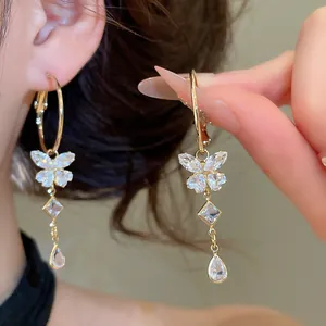Detailed view of elegant gold hoop earrings with sparkling zircon butterfly tassels.