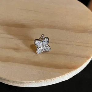 Detailed macro view of a sparkling butterfly-shaped zirconia ear cuff on a wooden base