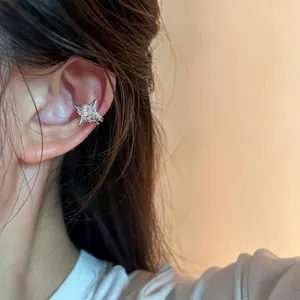 Detail of a sparkling zircon star ear cuff worn on an ear for a minimalist look.
