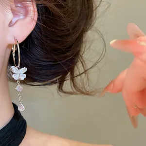 Close-up of elegant butterfly tassel earrings with sparkling cubic zirconia on model