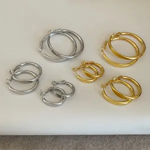 Set aus polierten Creolen in verschiedenen Größen mit goldenen und silbernen Metalloberflächen