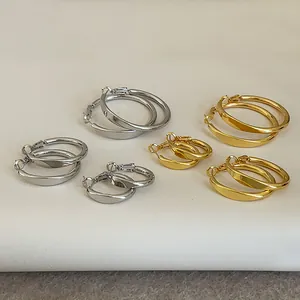 Auswahl an minimalistischen Creolen in Gold und Silber auf neutralem Untergrund