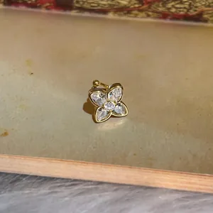 Macro detail of a sparkling zirconia butterfly ear cuff in a gold-toned finish