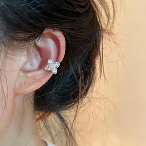 Close-up of a sparkling silver zircon flower ear cuff worn on the ear cartilage.