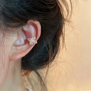 Macro view showing a sparkling zircon flower ear cuff on a model's ear cartilage detail