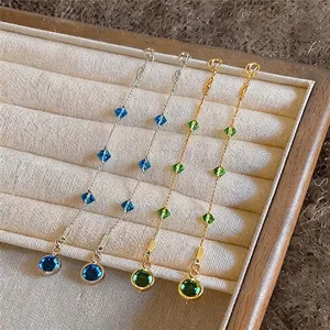 Elegante Quastenohrringe in Silber und Gold mit blauen und grünen Zirkoniasteinen
