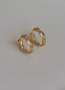 Detail der komplizierten gedrehten Textur dieser minimalistischen Goldcreolen