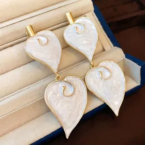 Elegante vintage hartvormige witte emaille druppeloorbellen met vergulde metalen rand