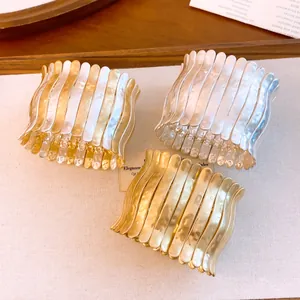 Detail von drei gewellten, plissierten elastischen Armbändern in Gold und Silber