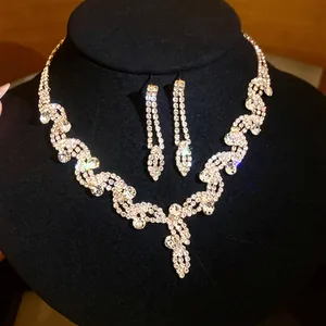 Elegante set di collana e orecchini con strass luccicanti e finitura color argento.