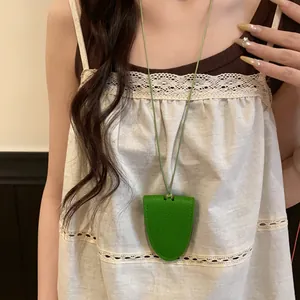 Détail d'un collier porte-lunettes élégant en cuir vert porté comme accessoire de mode