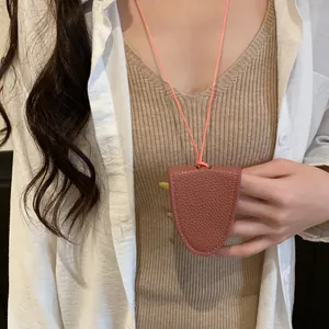 Gros plan d'un collier porte-lunettes en cuir portable sur un cordon orange élégant