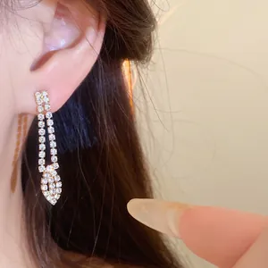 Primo piano dettagliato di eleganti orecchini lunghi con strass su una modella asiatica