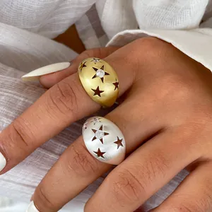 Detailansicht matter Gold- und Silberringe mit Sternen und Zirkonia an der Hand