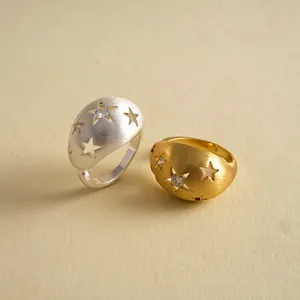 Detaillierte Makroansicht von vergoldeten und versilberten Sternenringen mit Zirkonia-Steinen.